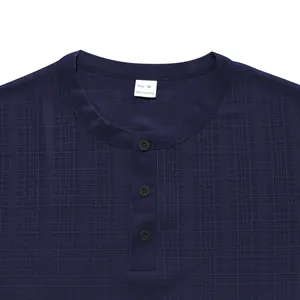 Détail du col d'un t-shirt Henley bleu marine avec texture gaufrée et trois boutons