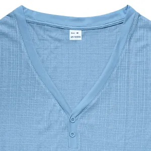Detailopname van blauw Henley-shirt met V-hals, knopen en linnenachtige textuur