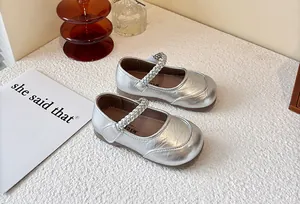 Silver metallic children's Mary Jane shoes with braided straps on white background