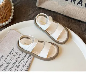 Detail view of white girls' sandals with soft brown soles and hook-and-loop straps