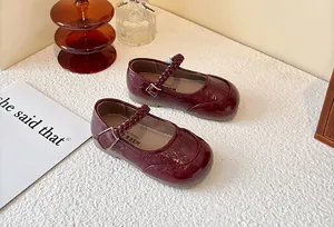 Detailed view of burgundy patent leather kids Mary Jane shoes featuring elegant braided straps