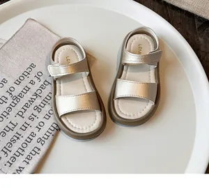 Close-up detail of champagne gold girls' sandals featuring soft soles and open toes.