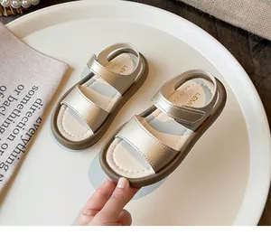 Close-up of champagne silver girl's sandals with soft sole and adjustable velcro straps