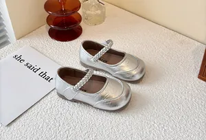 Close-up of elegant silver metallic Mary Jane shoes for girls featuring braided straps