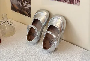 Detail view of silver metallic Mary Jane shoes for girls with braided strap detail