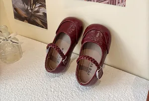 Detailed macro view of red glossy textured patent leather Mary Jane shoes for girls
