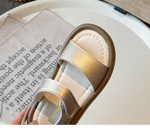 Detailed close-up view of a golden girl's sandal featuring soft sole and open toe