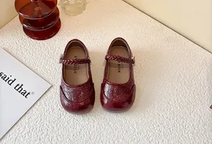 Detailed close-up of burgundy girl's Mary Jane princess shoes with a braided strap design