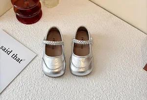 Top view of elegant silver girls Mary Jane princess shoes with a woven strap detail