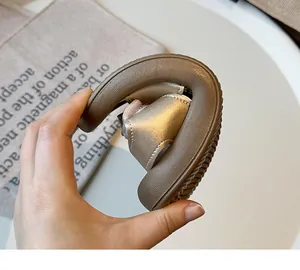 Detail of gold girl's sandal showing extreme sole flexibility and soft material