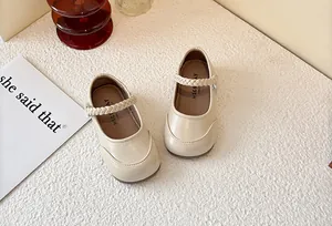 Close-up of elegant cream girls' Mary Jane shoes featuring a woven strap design