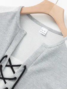 Close-up of men's waffle knit shirt with lace-up neck and size label detail