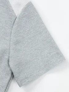 Close-up of grey waffle knit fabric and shoulder mesh detail on a men's short sleeve t-shirt
