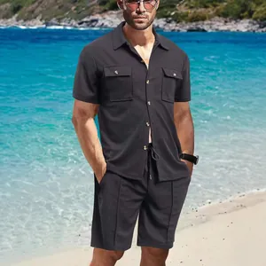 Detailansicht eines schwarzen Waffelstrick-Workwear-Sets für Herren am sonnigen Strand.