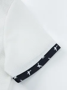 Close-up of white waffle texture shirt sleeve with navy bird pattern cuff details.