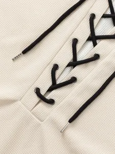 Detailed macro shot of men's waffle knit T-shirt featuring a black lace-up neck design