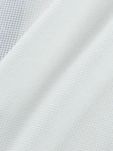 High-quality close-up detail of white waffle knit fabric texture for men's casual T-shirt