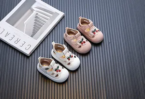 Detailed view showing the cute cherry design on white and pink toddler sandals for girls
