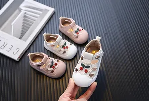 Detailed macro view of white toddler girl sandals with cute cherry embroidery pattern