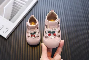 Detailed view of pink toddler sandals with lace heart and cherry embroidery details