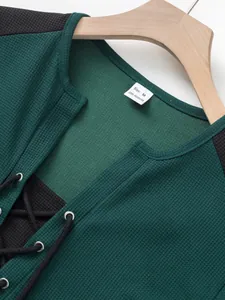 Close-up detail of waffle knit fabric and lace-up design on men's green casual t-shirt