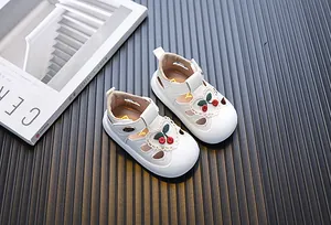 Detailed view of white toddler girl sandals with cute cherry embroidery and heart lace