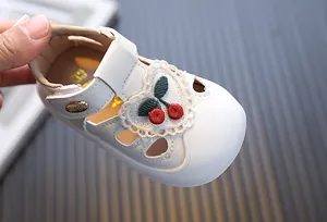 Close-up of white toddler girl summer sandals featuring delicate cherry embroidery and soft soles