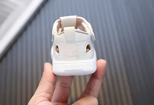 Close-up view of the reinforced heel and stitching detail on beige baby walking sandals