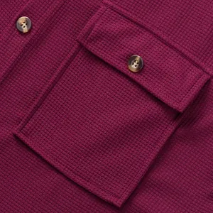 Close-up of burgundy waffle knit shirt showing the chest pocket and textured buttons.