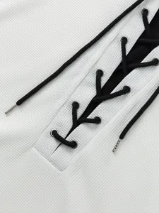 Détail macro du tissu en maille gaufrée blanche avec décolleté à lacets noirs contrastés