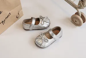 Detailed view of silver metallic pleated Mary Jane shoes for girls featuring a cute bow