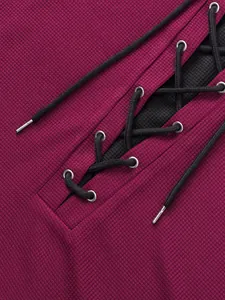 Detailed macro view of waffle knit texture and black lace-up design on magenta garment