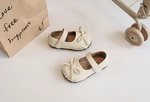 Detailed view of beige pleated children's Mary Jane shoes with elegant bow and soft sole