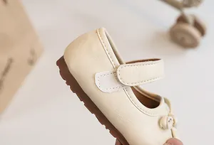 Close-up showing the Velcro strap detail on cream soft-sole girls' princess leather shoes.
