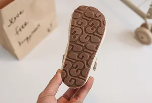 Close-up of brown textured non-slip rubber sole for children's princess shoes in size 23.
