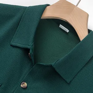 Close-up of dark green waffle knit texture and collar on a men's shirt