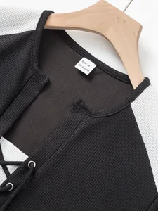 Detail of waffle knit men's t-shirt featuring lacing design and 100% polyester tag