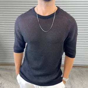 Detalle de camiseta negra de punto calado que muestra la textura transpirable y el ajuste