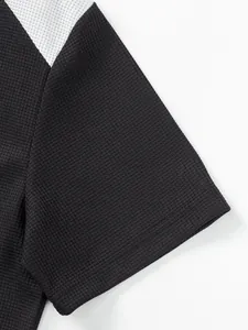 Macro view showing waffle knit texture and color-block sleeve of a men's casual t-shirt