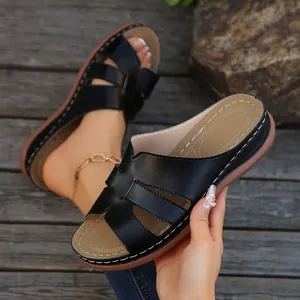 Vista detallada de sandalias de cuña negras para mujer con diseño de tiras cruzadas