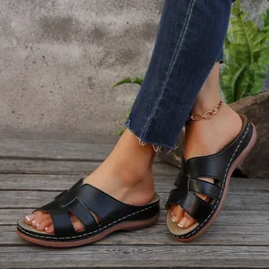 Vista detallada de sandalias de cuña negras para mujer con costuras blancas en contraste