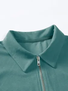 Nahaufnahme eines Herren-Sportpoloshirts mit halbem Reißverschluss in blaugrünem Pikee