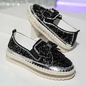 Detailed view of stylish black rhinestone loafers with bow detail and platform sole