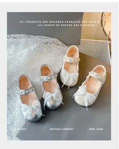 Elegant silver and beige girls' Mary Jane shoes with lace bows and pearl-studded straps.