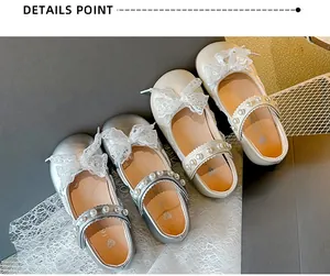 Detailed view of girls' Mary Jane shoes with lace bows and pearl straps