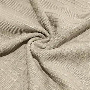 Close-up macro view of beige slub cotton fabric texture for men's vintage Henley t-shirt.