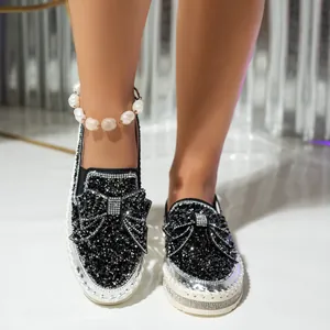 Detailed view of stylish black rhinestone bow loafers with thick platform soles for women.