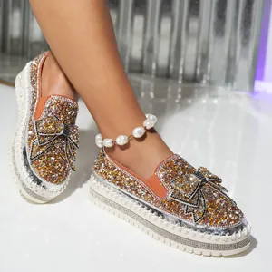 Close-up of glamorous rhinestone loafers featuring a sparkling bow detail and platform sole.