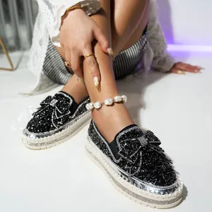 Macro view of the sparkly black rhinestone bow on high quality platform slip-on shoes