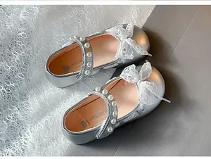 Close-up of silver girls' Mary Jane shoes featuring elegant lace bows and pearl straps